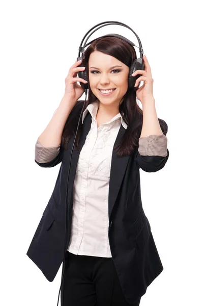 Young girl in a jacket and blouse, listening to music in headpho — Stock Photo, Image