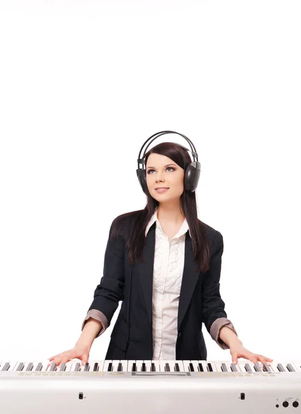 Young girl in a jacket and headphones playing a synthesizer, iso — Stock Photo, Image