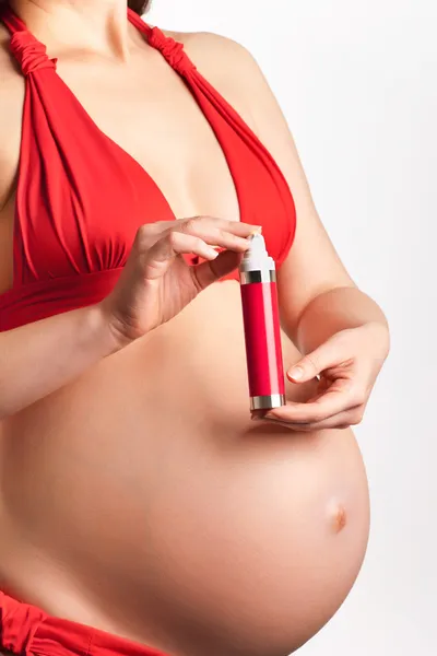 Pielęgnacja skóry w ciąży: młoda kobieta w ciąży z kremem do ciała, cl — Zdjęcie stockowe
