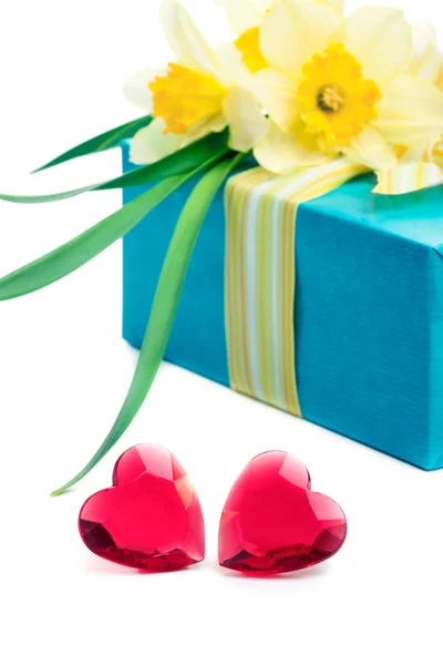 Dois corações de vidro vermelho com uma caixa de presente e flores, em branco — Fotografia de Stock