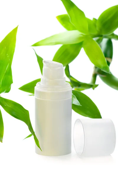 Gezicht room/serum/lotion/moisturizer onder bamboe bladeren — Stockfoto
