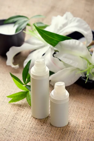 Face/body care concept: lily flower with creams — Stock Photo, Image