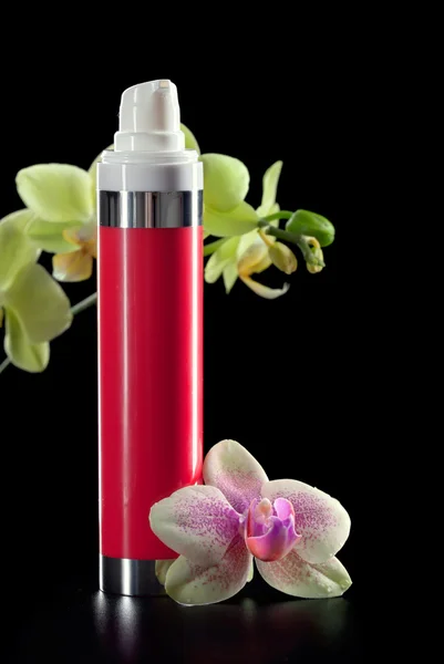 Bottle of face cream/lotion with orchid flowers, closeup shot, o — Stock Photo, Image