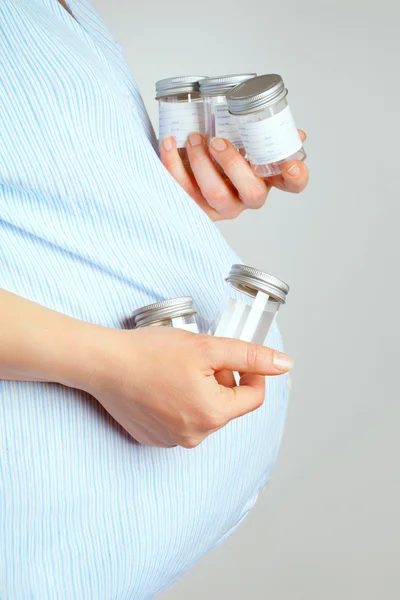Беременная женщина с контейнерами для сдачи проб мочи, беременная — стоковое фото