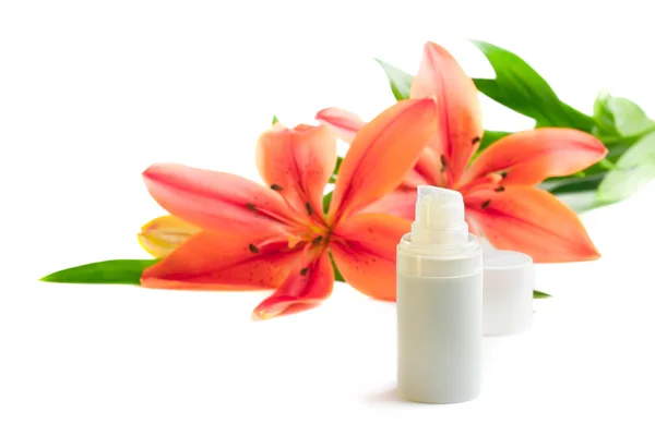 Bottle of cream/lotion with lily flowers, closeup shot, on white — Stock Photo, Image