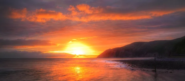 Belo nascer do sol vibrante sobre a paisagem de praia de maré baixa — Fotografia de Stock