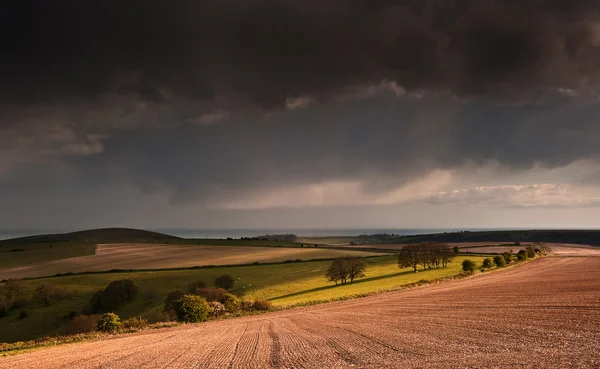 Stunning landscape with stormy sky over rural hills — Stock Photo, Image