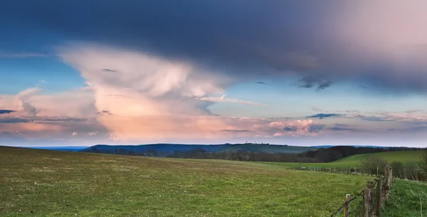 Stunning landscape with stormy sky over rural hills — Stock Photo, Image