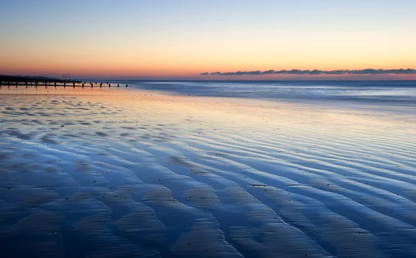 Vackra lågvatten beach pulserande sunrise — Stockfoto