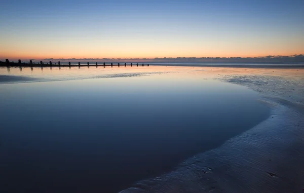Красивий пляж з низьким припливом яскравий схід сонця — стокове фото
