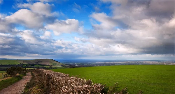 Countryside landscape path leading through fields towards dramat — Stock Photo, Image