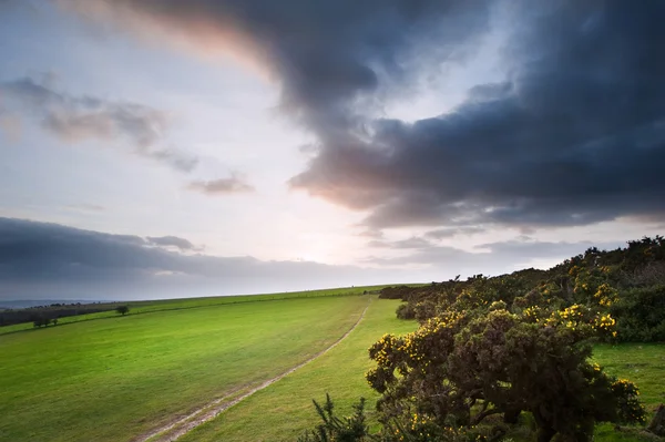 Countryside landscape path leading through fields towards dramat — Stock Photo, Image