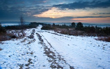 Vibrant Winter sunrise landscape over snow covered countryside