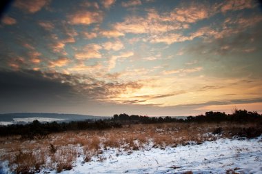 Vibrant Winter sunrise landscape over snow covered countryside