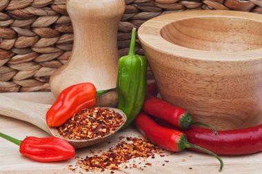 Crushed and whole chilli peppers in rustic kitchen setting clipart