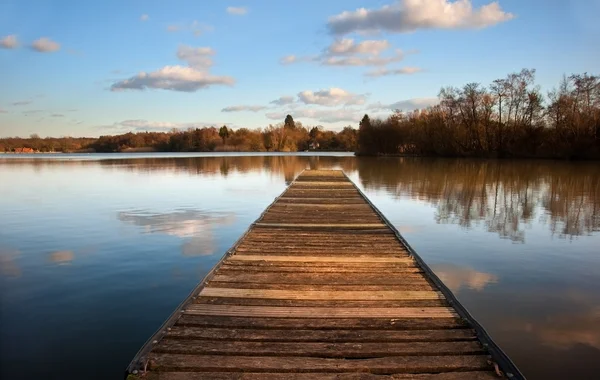 Paesaggio di pontile di pesca sul lago calmo al tramonto con reflectio — Foto Stock