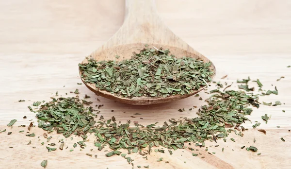 Chopped tarragon on wooden serving spoon with selective focus