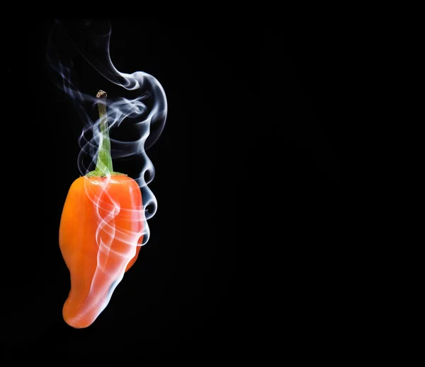 Smoking orange hot chilli pepper — Stock Photo, Image