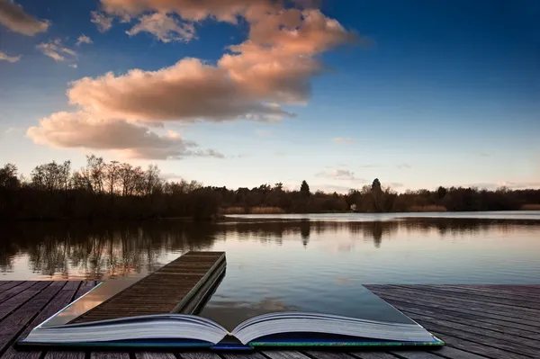 Zonsondergang landschap over steiger op meer coming out van magische boek pag — Stockfoto
