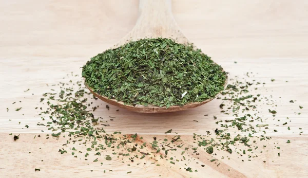Chopped coriander cilantro leaf on wooden serving spoon with sel — Stock Photo, Image