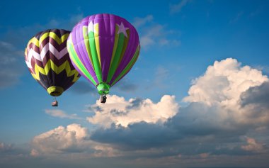 Stunning blue sky cloud formations with hot air balloons clipart