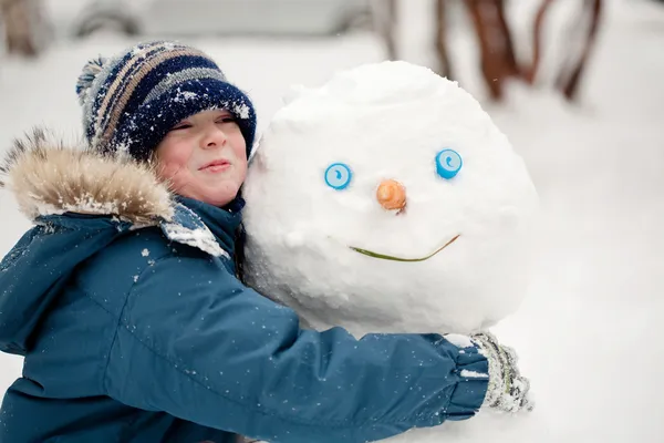 Dítě a sněhulák — Stock fotografie