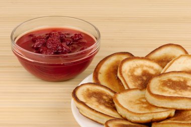 Heap of pancakes with bowl of strawberry jam clipart