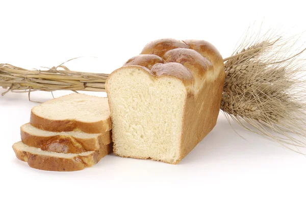 stock image Sliced loaf of bread with spikelets isolated on white