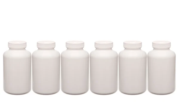 Blanco píldoras contenedores en una fila aislada en blanco — Foto de Stock