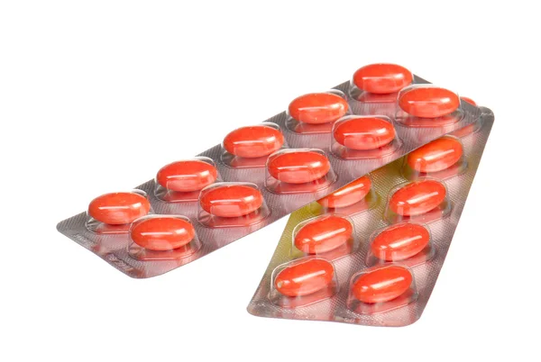 Close up orange capsules and blisters isolated on white — Stock Photo, Image