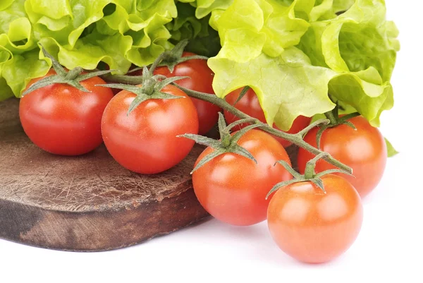 Cherry tomatoes and salad on cutting board — Stock Photo, Image