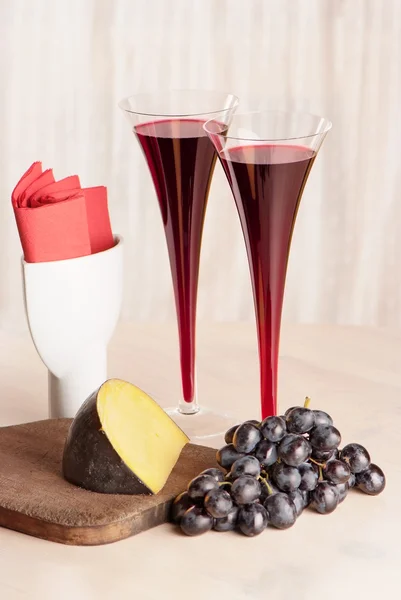 Dois copos de vinho tinto, queijo e uva na mesa — Fotografia de Stock