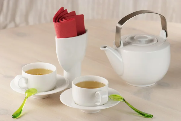 Zwei Tassen grüner Tee und Teekanne auf dem Tisch — Stockfoto