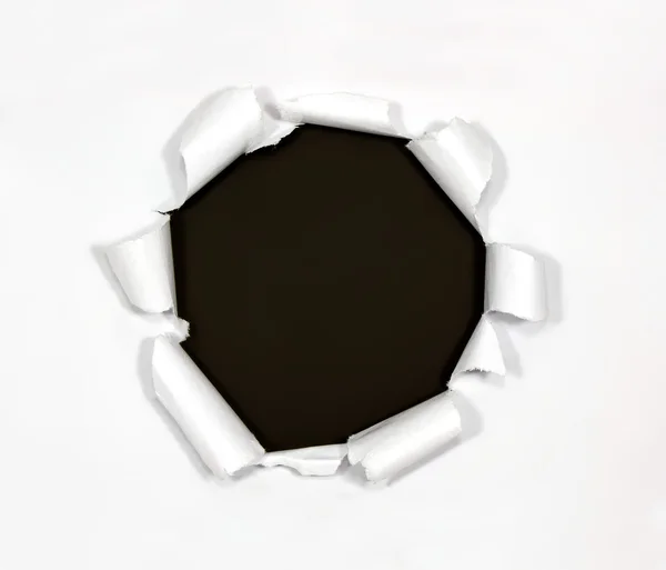 Круглая дыра в бумаге на черном фоне — стоковое фото