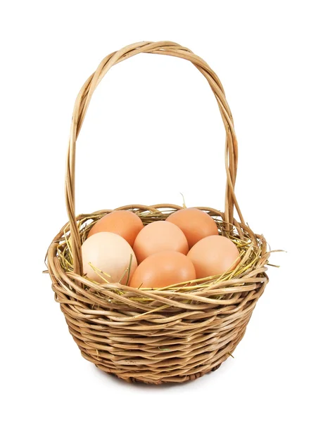 Bruna ägg på hö i korgen — Stockfoto