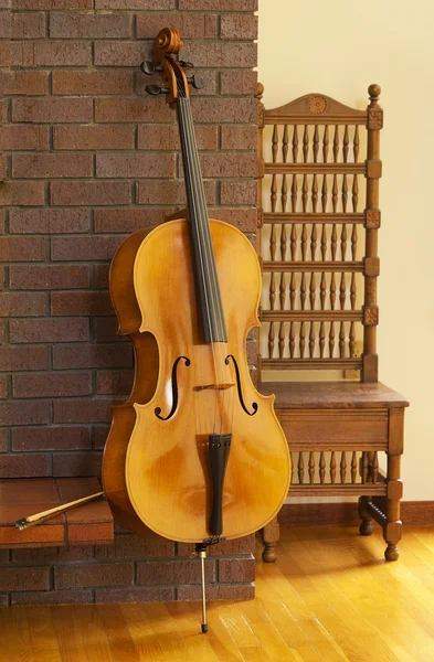 Cello resting on a fireplace — Stock Photo, Image