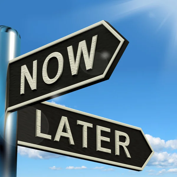 Agora ou mais tarde Signpost mostrando prazos de atraso e urgência — Fotografia de Stock