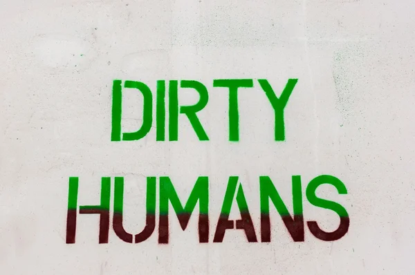 Dirty humans written on white wall — Stock Photo, Image