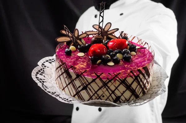 stock image Holding cake against dark background