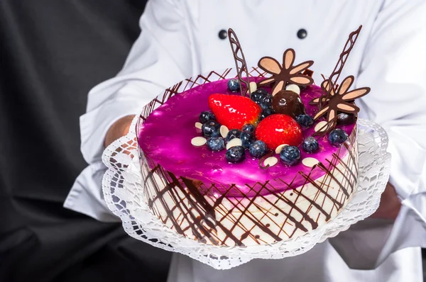 stock image Holding cake against dark background