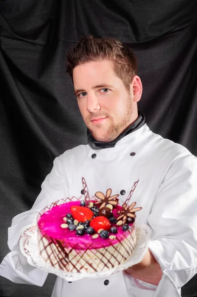 Handsome confectioner with cake — Stock Photo, Image