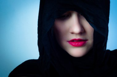 Girl in black hood against blue background clipart