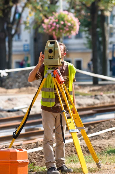 Arbetstagaren inspektera platsen med sin stativ och industriella enhet — Stockfoto