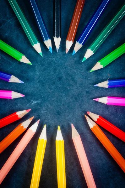 Crayons colorés sur fond sombre en cercle — Photo