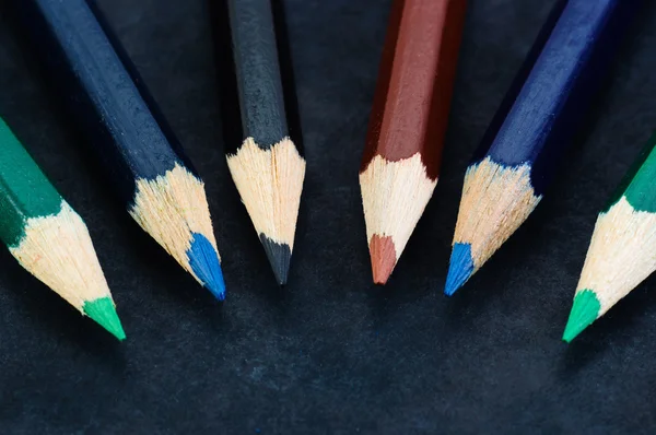 Lápis coloridos no fundo escuro alinhados — Fotografia de Stock
