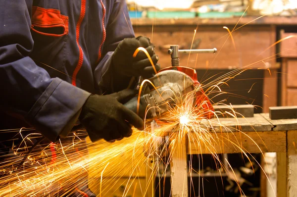 Cirkelzaag en een werknemer in een harde baan — Stockfoto