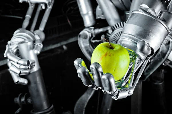 Зеленое яблоко в руках робота — стоковое фото