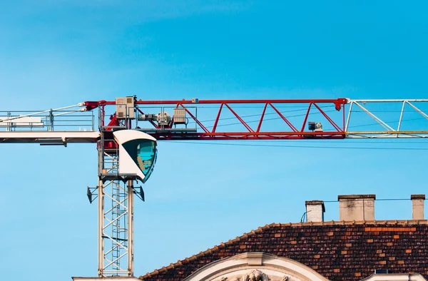 Wielkie przemysłowe dźwig przeciw błękitne niebo, budowa domu — Zdjęcie stockowe
