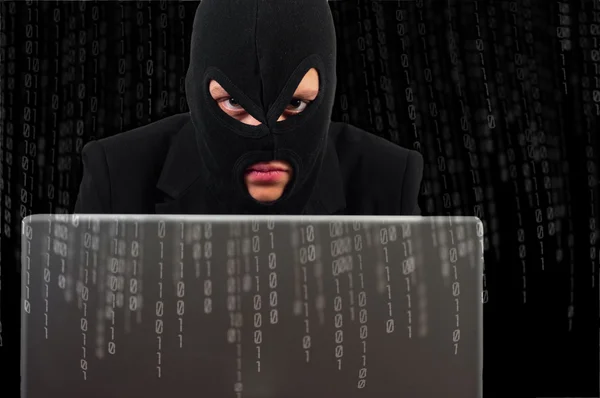 A hacker with a laptop against binary background — Stock Photo, Image