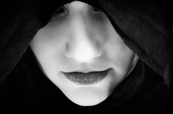 Frau mit schwarzer Kapuze, konzentriert auf ihre Lippen — Stockfoto